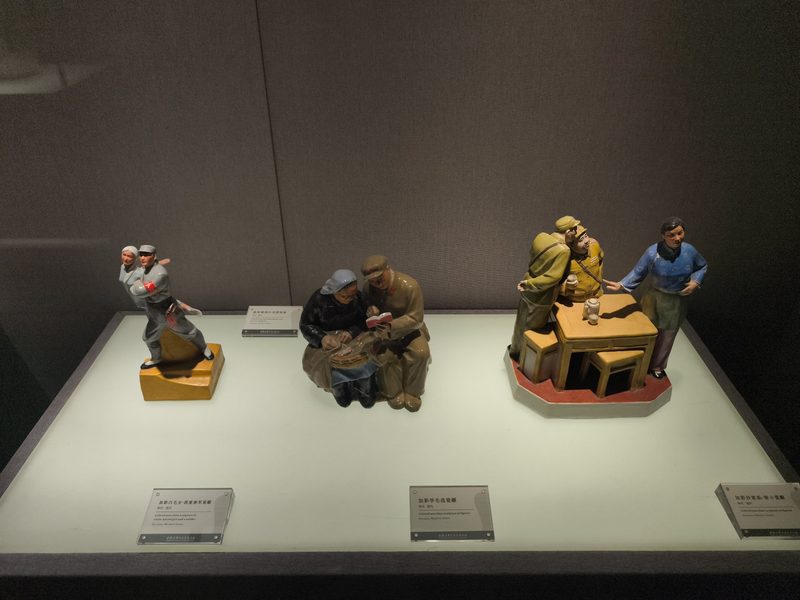 展柜中三组加彩人物瓷塑并排陈列