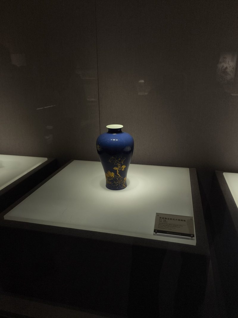 祭蓝釉描金花卉纹瓶，立在展台上