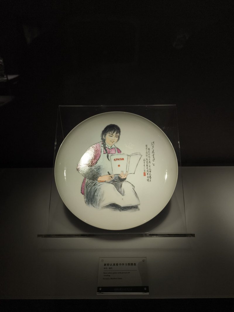 白瓷盘上绘着一位低头读书的女子